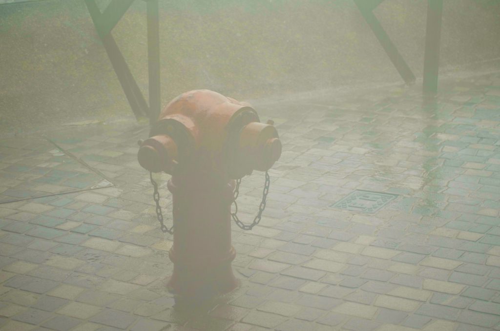 A lone fire hydrant sits in driving rain