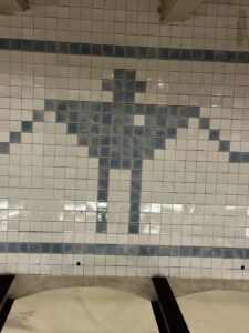 A subway wall tiled with tiles making the dhs;evof a robot