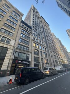 a collection of buildings, with varying heights and bearing frontal facades along fifth Avenue