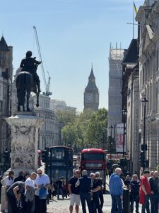 looking down Trafalgar Square, the nelson statue in the foreground and buildings in the background. You can see Elizabeth tower in the distance.