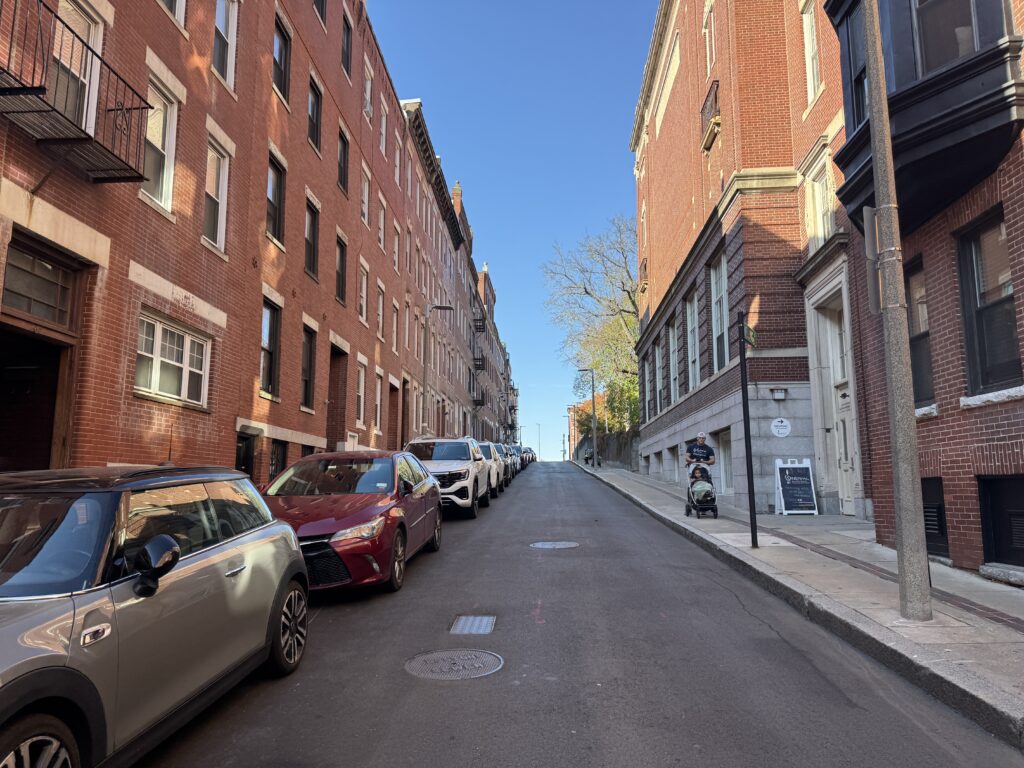 A street scape, red brick buildings line the street.
