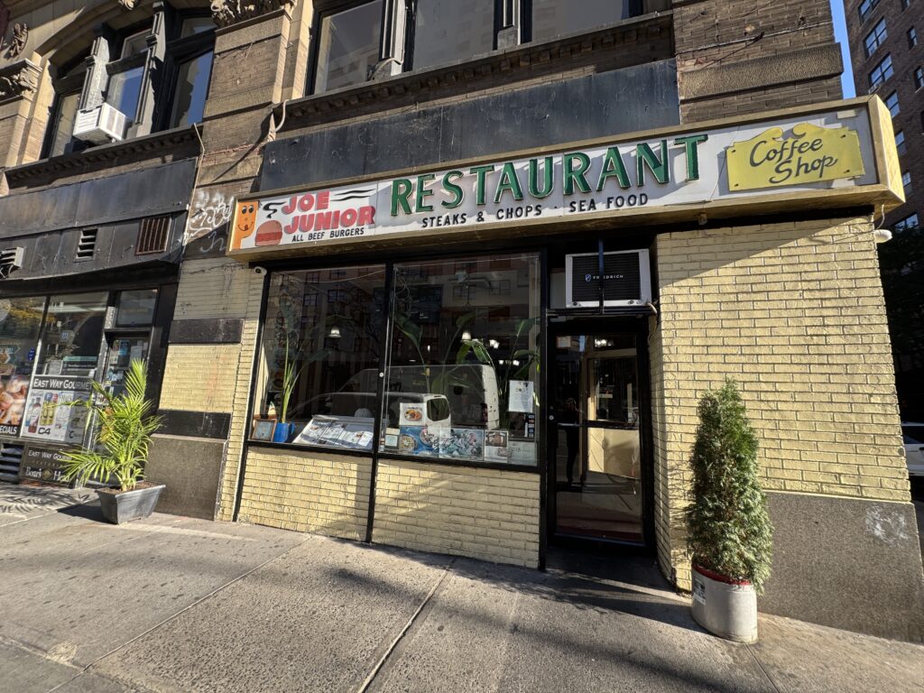 The front of Joe junior diner. Sign above, a window and yellow bricks